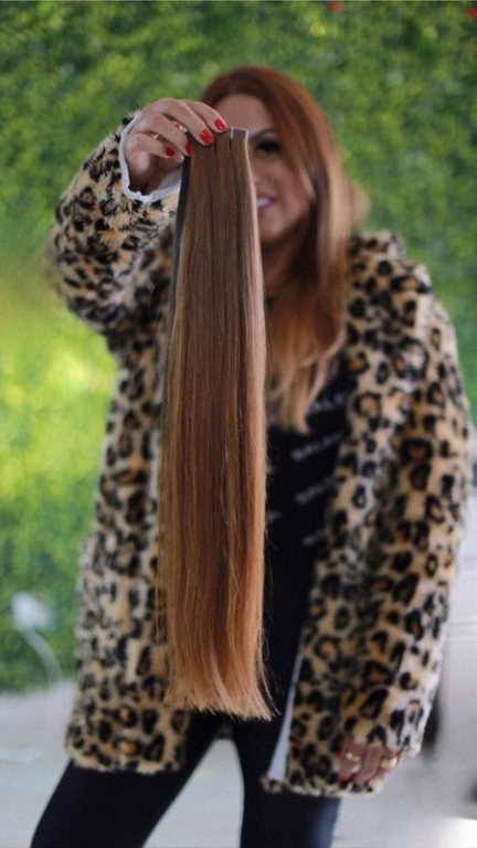 Ingrid Desirée segurando uma mecha de mega hair castanho
